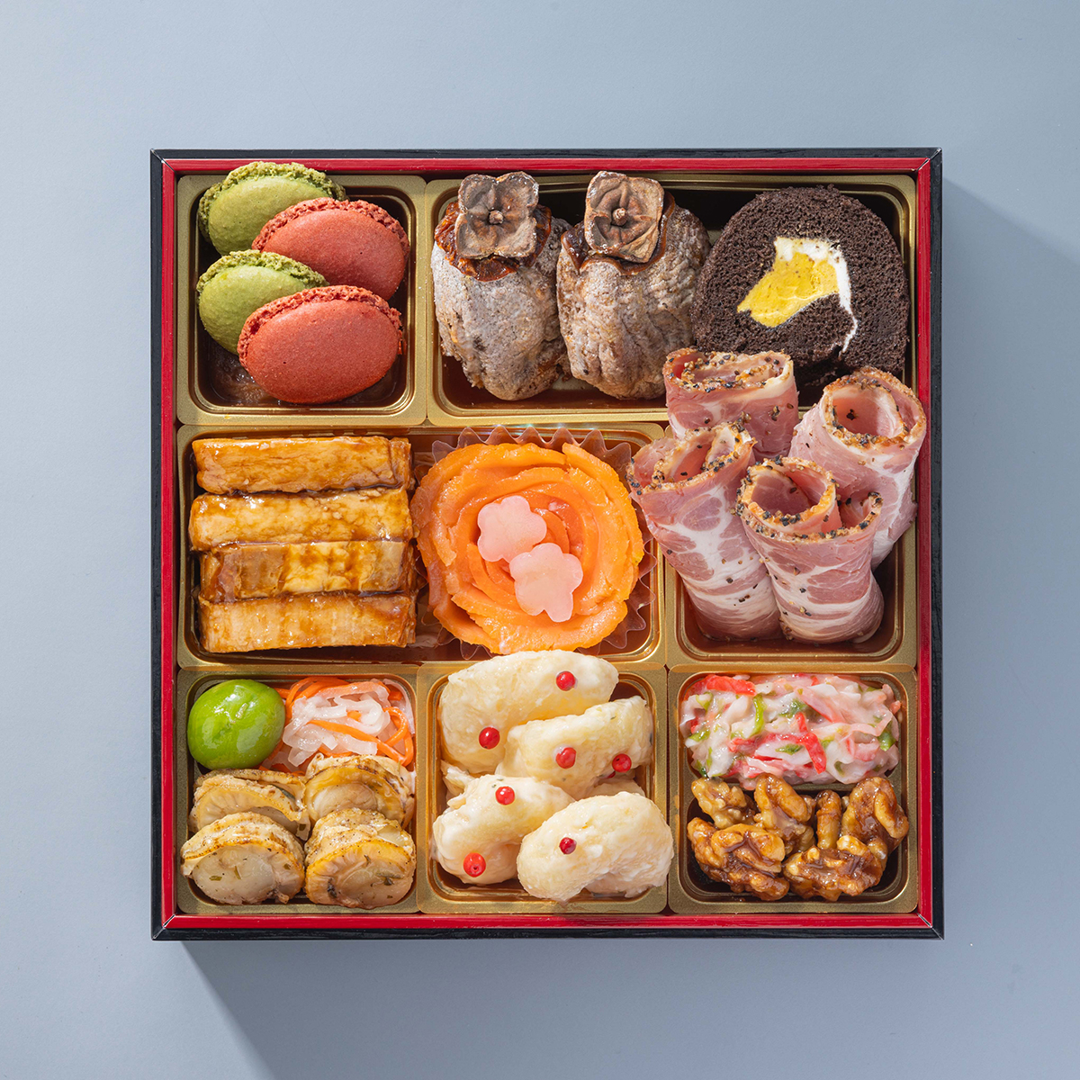 三の重：抹茶マカロン、木いちごマカロン、マロン餡、干柿ホワイトチョコ、チョコバナナロールケーキ、やわらか豚角煮、スモークサーモン、梅百合根、海老のタルタル和え、蟹とあおさのサラダ、くるみ甘露煮、ボークパストラミ、若桃甘露煮、紅白なます、帆立香草焼